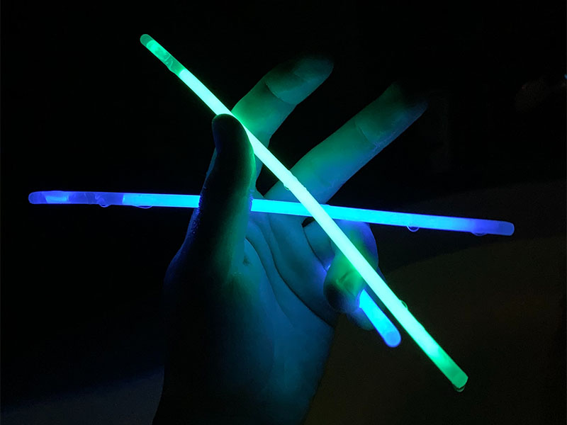 Can You Bring Glow Sticks on Planes? 1 Blue and Green glow sticks held in hand