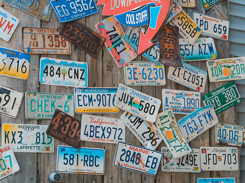 Can You Bring License Plates on Planes? 1 Multiple US license plates on a wooden wall