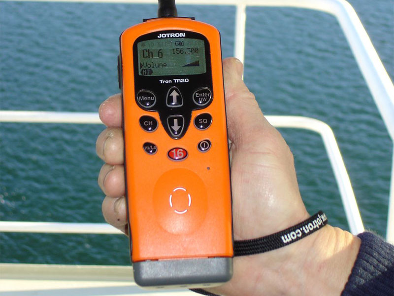 A man holding a marine VHF radio device