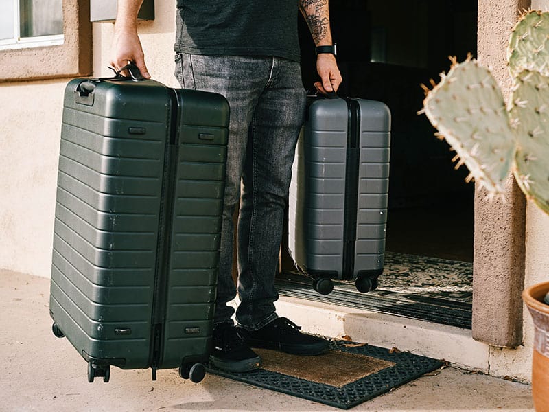 What to Do With Luggage After Checking Out From Hotel 1 Man holding two hardside suitcases
