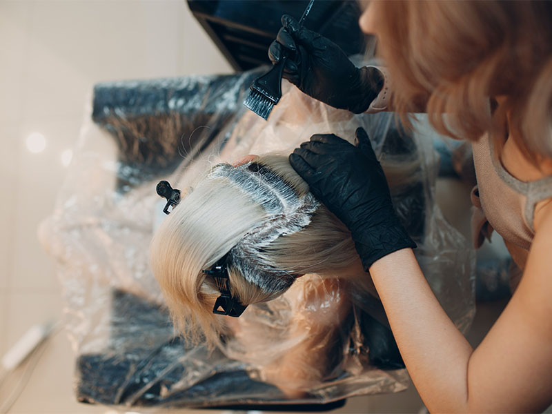 Can You Bring Hair Dye on a Plane? (TSA Rules) 1 A woman applying hair dye